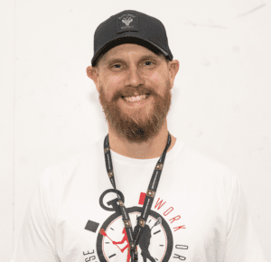 A man wearing a hat and a lanyard.