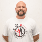 A man wearing a white shirt with a clock on it.