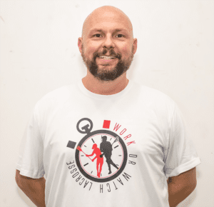 A man wearing a white shirt with a clock on it.